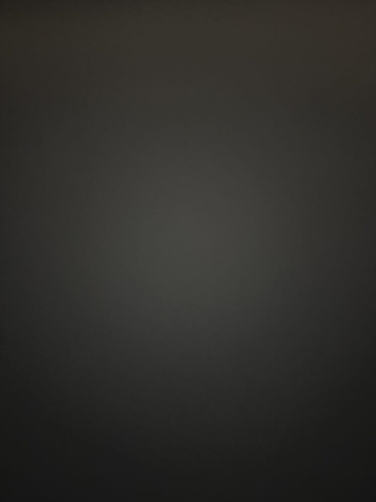A blank or nearly entirely dark gray background with no discernible subjects, text, or details visible.